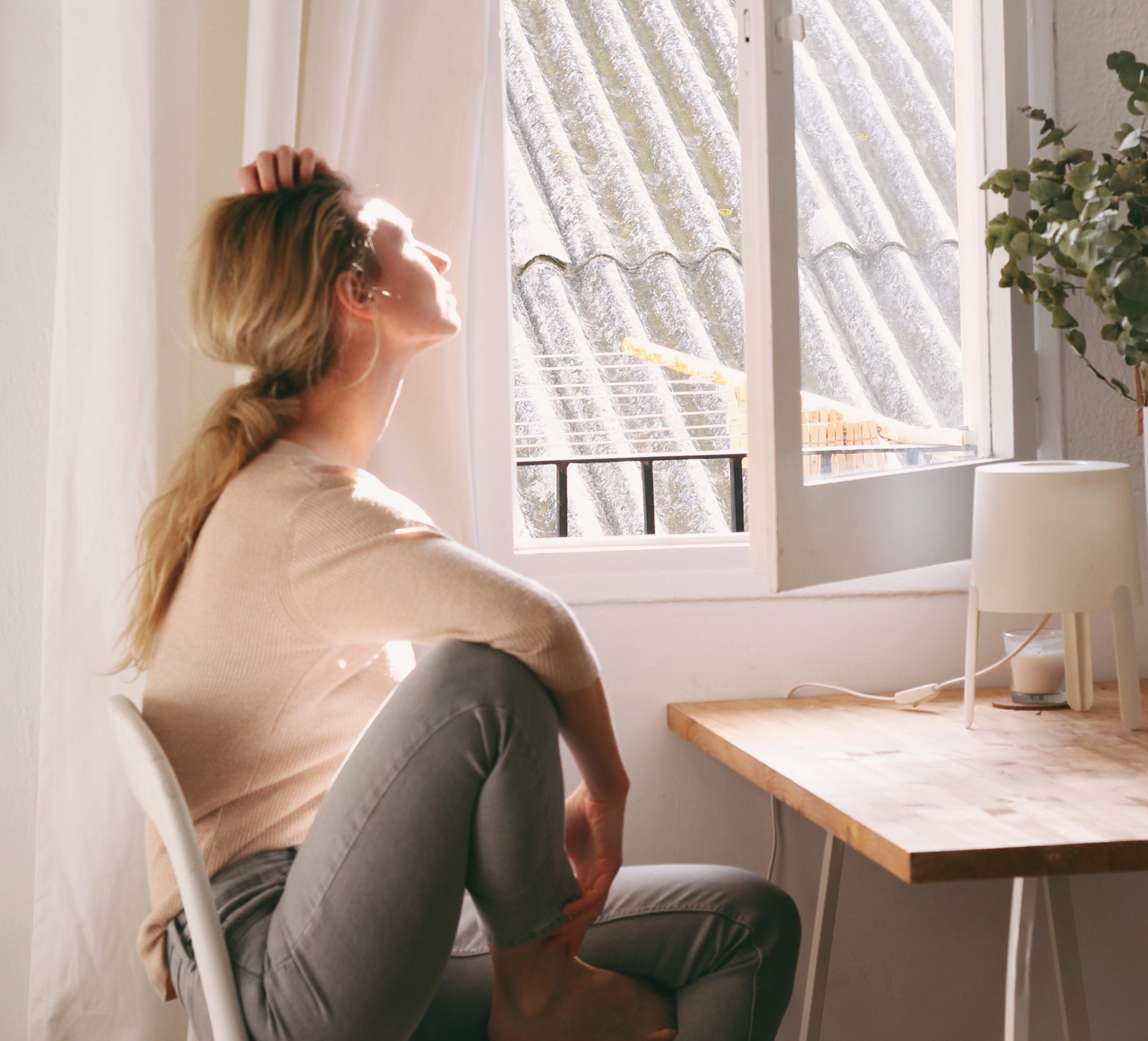 woman at desk looking out window